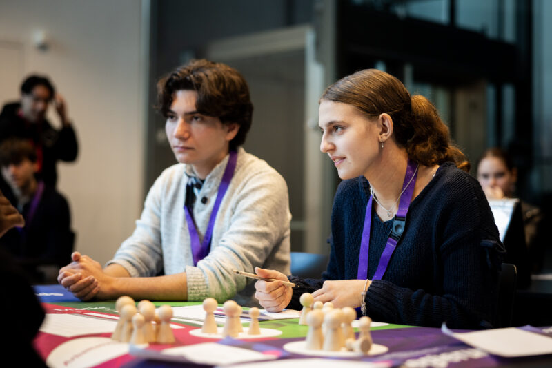 Eine Schülerin und ein Schüler spielen das Planspiel ECOMANIA