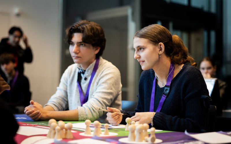 Eine Schülerin und ein Schüler spielen das Planspiel ECOMANIA